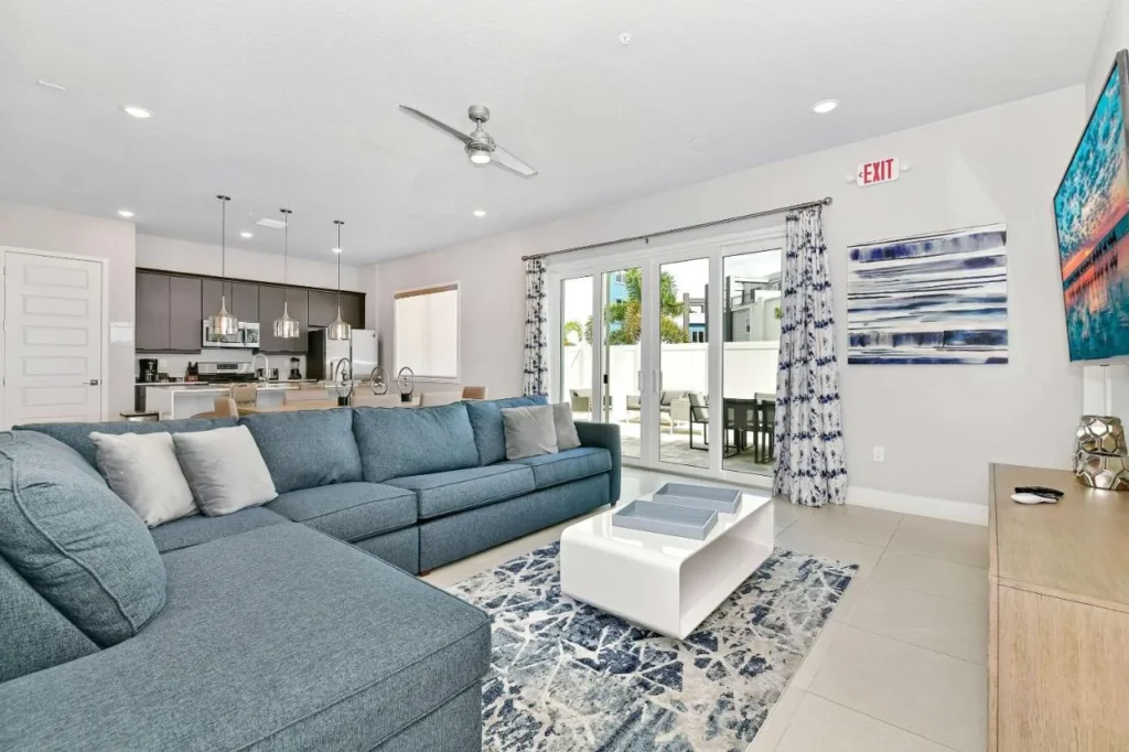 Spectrum Resort Orlando townhome living room with large blue sectional sofa and open kitchen behind