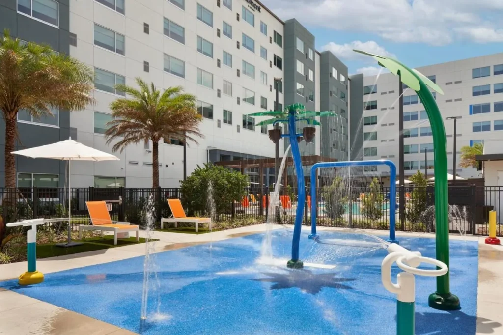 Splash pad con rociadores en forma de palma al lado del hotel en Aloft Orlando en SeaWorld