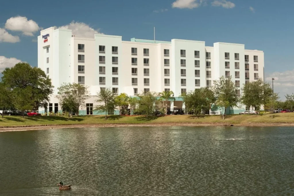 SpringHill Suites Orlando Airport edificio visto a trav&eacute;s de un lago con un pato en frente