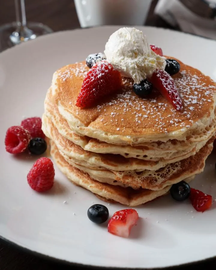 Stack of pancakes with fresh berries, powdered sugar and whipped topping at Hotel Beauden