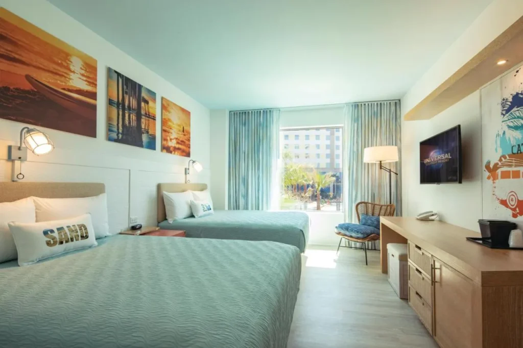 Habitación estándar con dos camas queen y obras de arte puesta de sol playa en Dockside Inn and Suites