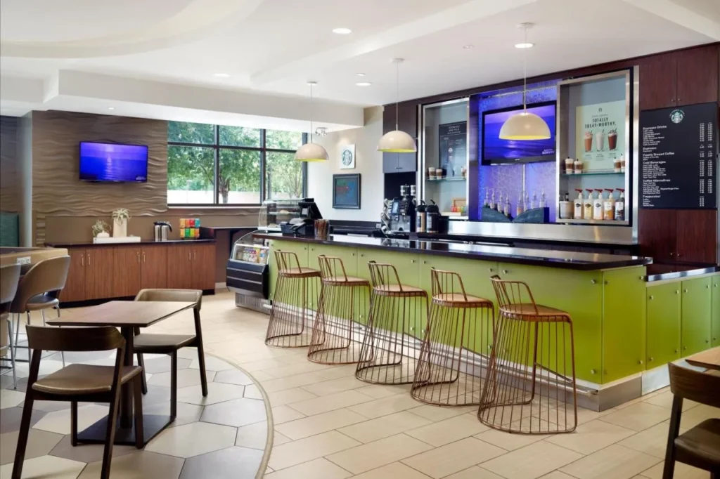 Starbucks coffee bar with lime-green counter and copper stools at SpringHill Suites Orlando at SeaWorld