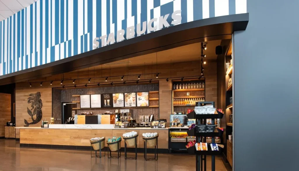 mostrador de Starbucks con tableros de men&uacute; y bocadillos para llevar en el vest&iacute;bulo del Universal Aventura Hotel