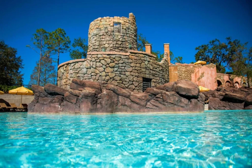 Torre de piedra y roca que se eleva sobre una piscina de color turquesa en Loews Portofino Bay Hotel