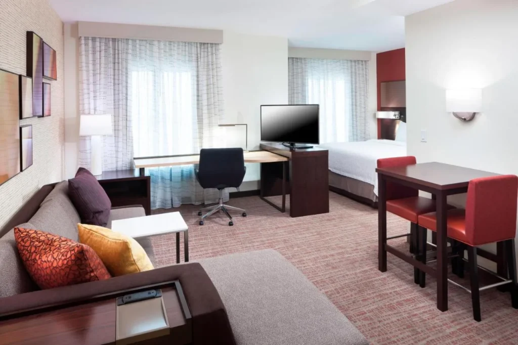 Suite estudio con sof&aacute;, escritorio, TV, mesa de comedor y cama en Residence Inn Near Universal Orlando