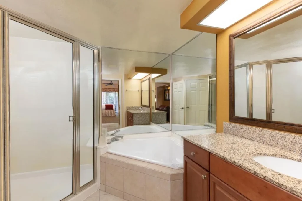 Studio villa bathroom with corner tub, glass shower and granite vanity at Westgate Lakes