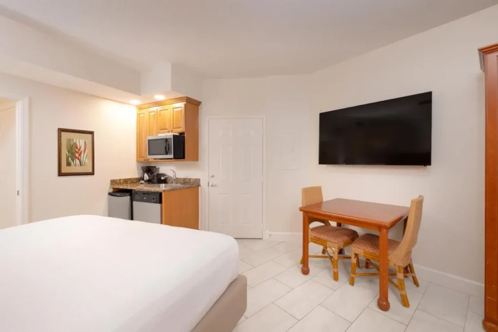 Studio villa with bed, kitchenette, wall TV and small dining table at Westgate Vacation Villas Resort