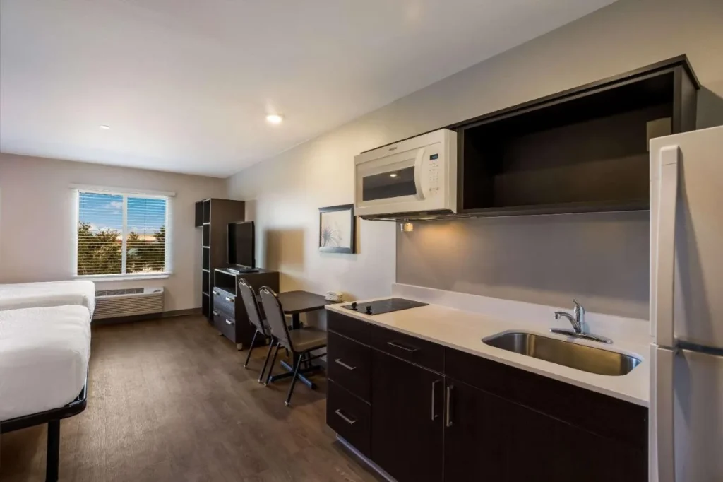 Studio with kitchenette, cooktop, microwave and full-size fridge at WoodSpring Suites Orlando West - Clermont