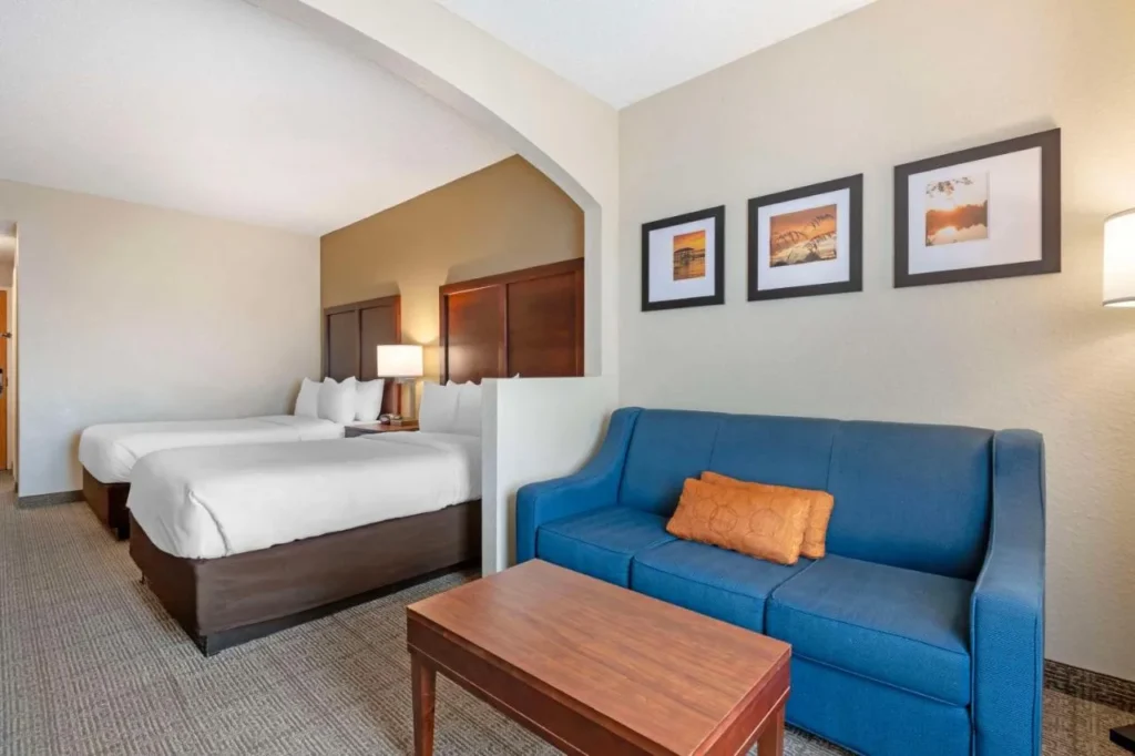 Suite at Comfort Suites Downtown Orlando with two beds and a blue sofa