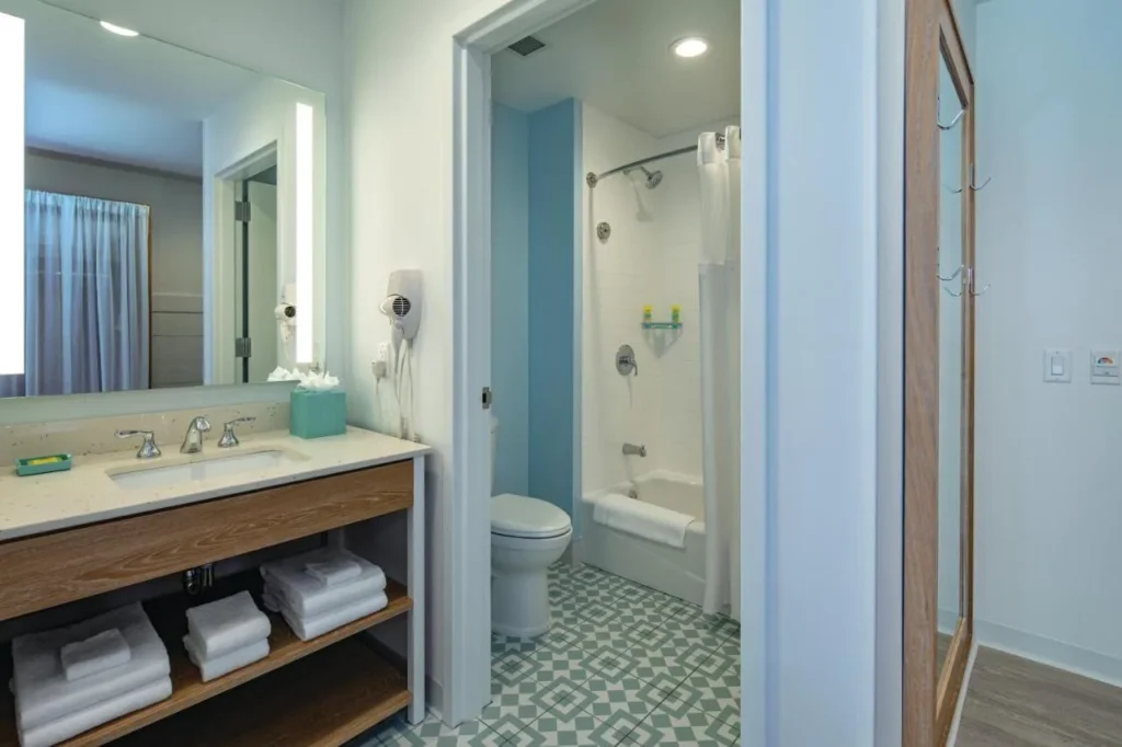 Cuarto de baño de la suite con una zona de tocador independiente y una bañera-ducha en Dockside Inn and Suites