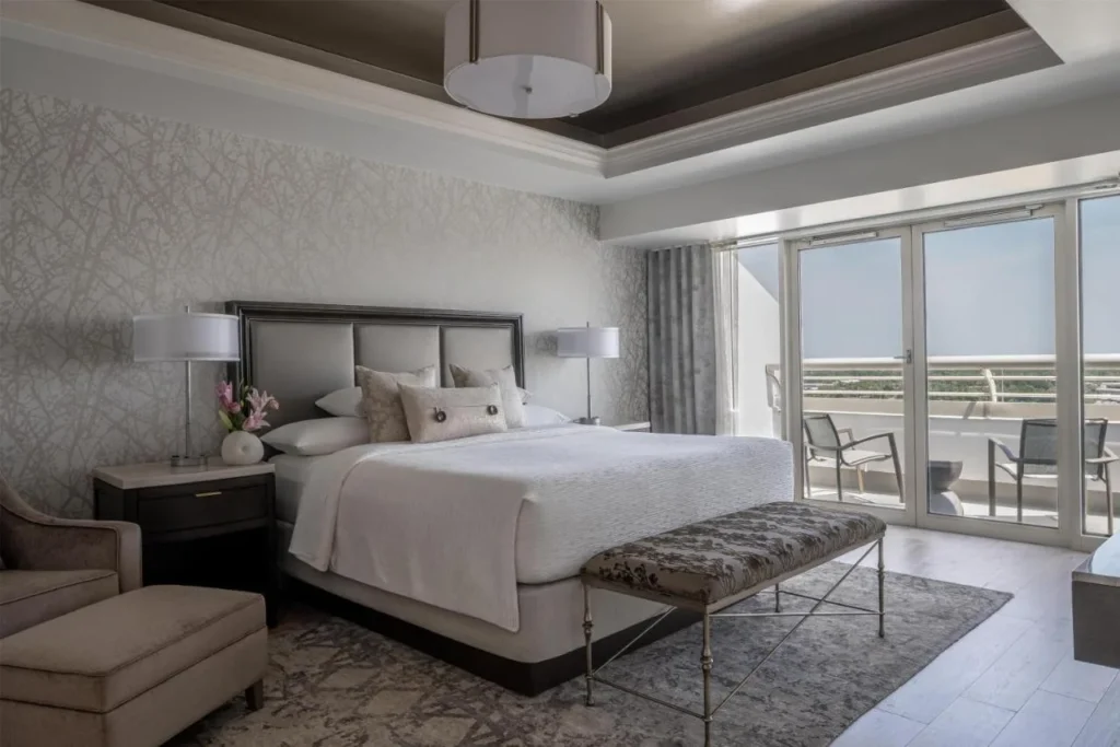 Suite bedroom with king bed, bench and furnished balcony at Hyatt Regency Orlando International Airport