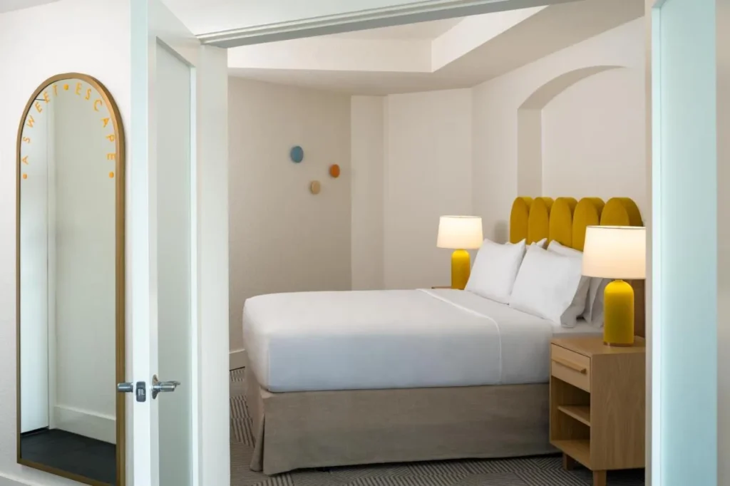 Dormitorio suite con cama grande y cabecera amarilla a través de una puerta en Renaissance Orlando Resort