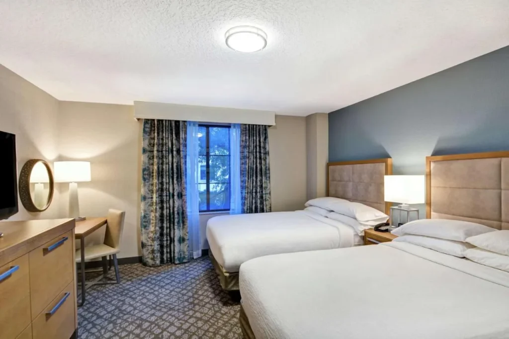 Suite bedroom with two beds and a desk at Embassy Suites by Hilton Orlando Downtown