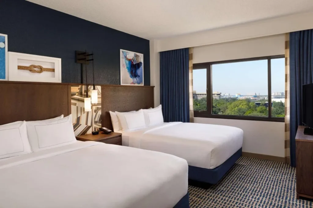 Habitaci&oacute;n suite con dos camas queen y una gran ventana en DoubleTree Suites Disney Springs