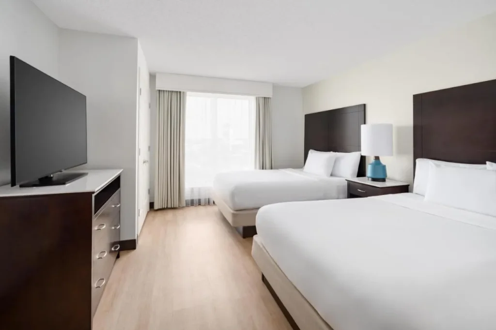Suite bedroom with two queen beds and a TV at Embassy Suites Lake Buena Vista Resort