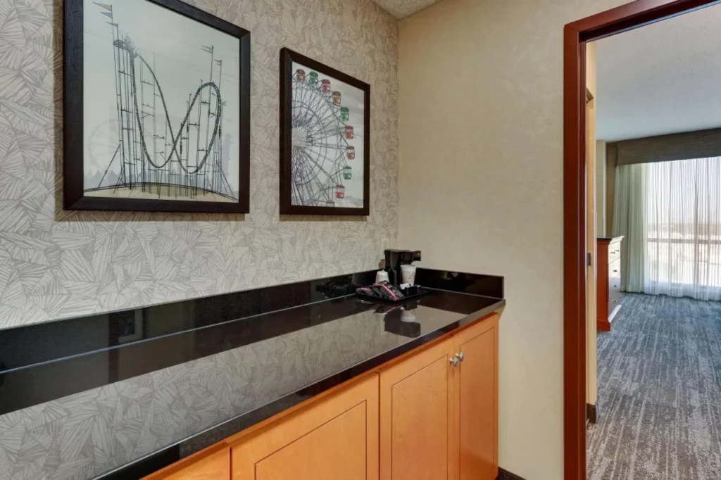 Suite counter with coffee maker under roller coaster artwork at Drury Inn & Suites near Universal
