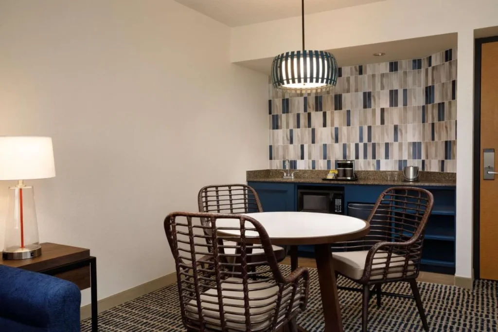 Mesa de comedor y wet bar con microondas y cafetera en el DoubleTree Suites Disney Springs