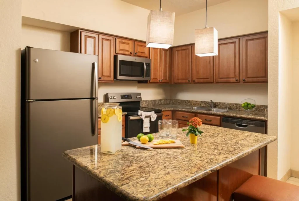 Cocina en suite con isla de granito, nevera grande, fogones y lavavajillas en Floridays Resort Orlando