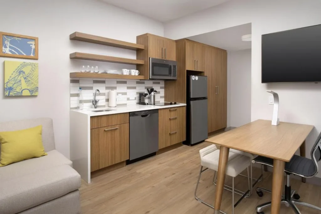 Cocina suite con lavavajillas, nevera, microondas y mesa de comedor en Element Orlando Universal Blvd.