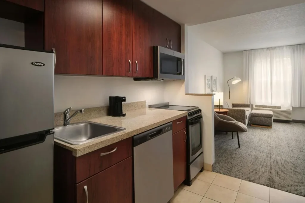 Suite de cocina con nevera completa, estufa, microondas y lavavajillas en TownePlace Suites The Villages