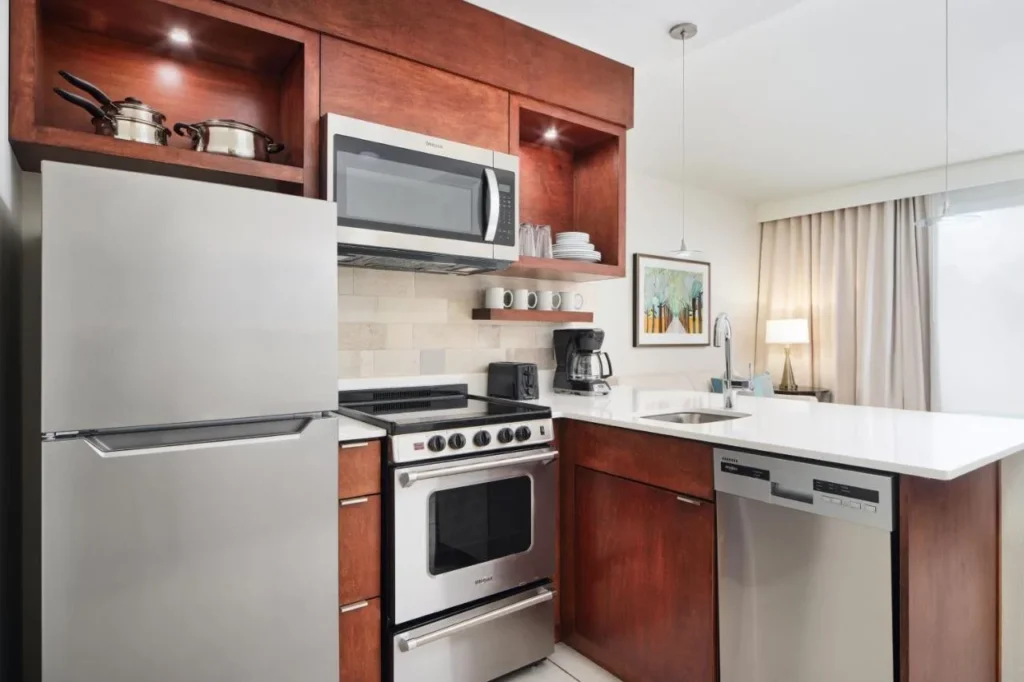 Suite de cocina con refrigerador, estufa, microondas y lavavajillas en TownePlace Suites Orlando Downtown