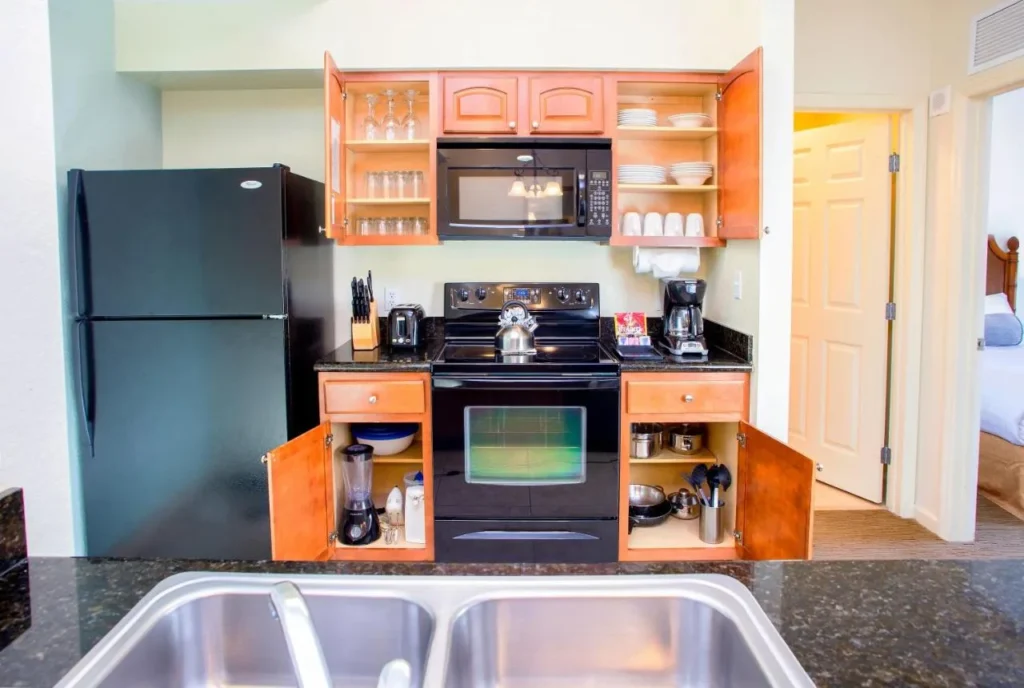 Suite kitchen with full-size stove, microwave, fridge and stocked cabinets at Lake Buena Vista Resort Village