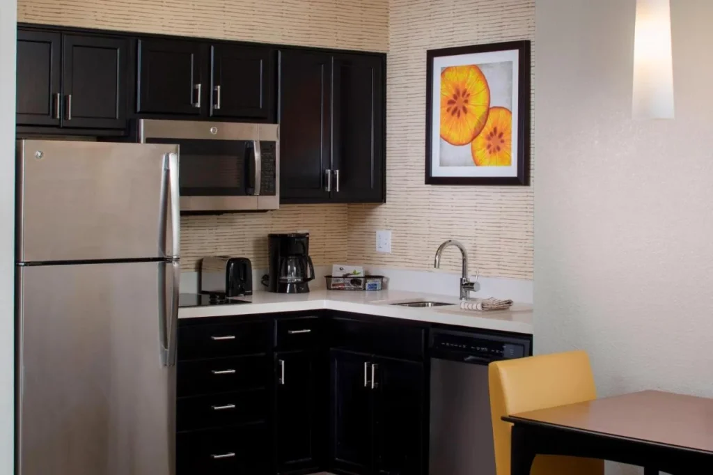 Suite de cocina con nevera de acero inoxidable, microondas, estufa y lavavajillas en el Residence Inn Orlando at SeaWorld