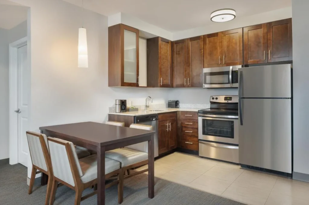 Cocina con estufa, lavavajillas, nevera de tama&ntilde;o completo y mesa de comedor en el Residence Inn Orlando Downtown