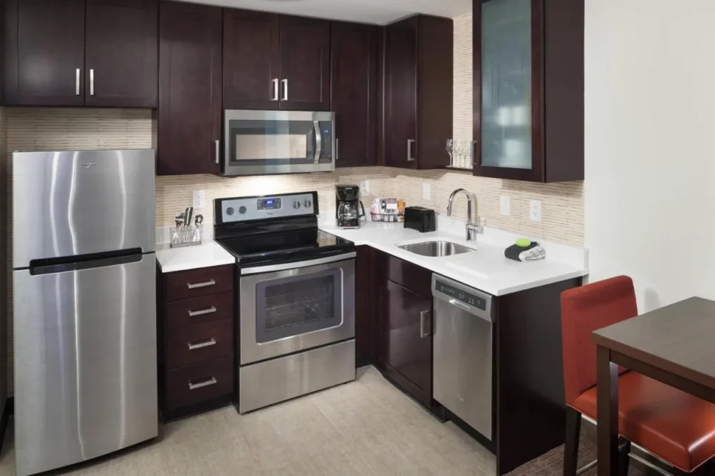 Suite de cocina con estufa, microondas, lavavajillas y refrigerador en el Residence Inn Near Universal Orlando