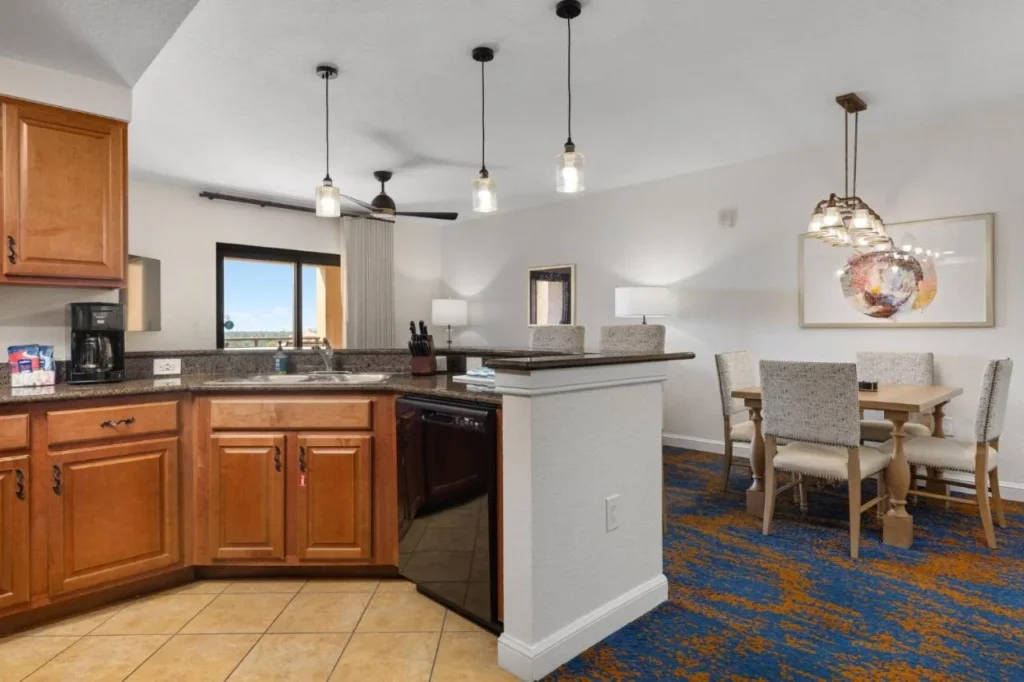 Cocina en suite con armarios de madera, barra de desayuno y mesa de comedor en Club Wyndham Bonnet Creek