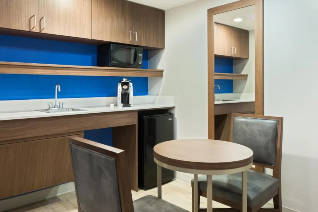 Suite kitchenette with sink, microwave, mini fridge and dining table at Holiday Inn Express Nearest Universal