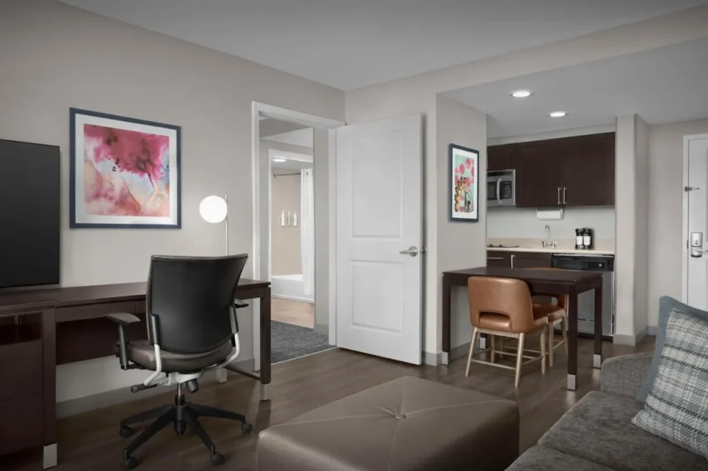Suite con escritorio, sof&aacute; y cocina compacta en Homewood Suites by Hilton Orlando Airport