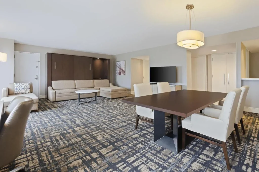 Suite con mesa de comedor y sofá seccional en Hilton Orlando Lake Buena Vista