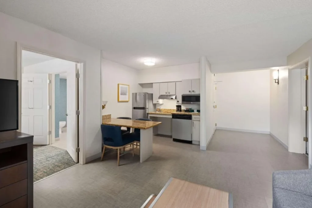 Sala de estar de la suite con cocina, lavavajillas y comedor en Homewood Suites Lake Mary Orlando North