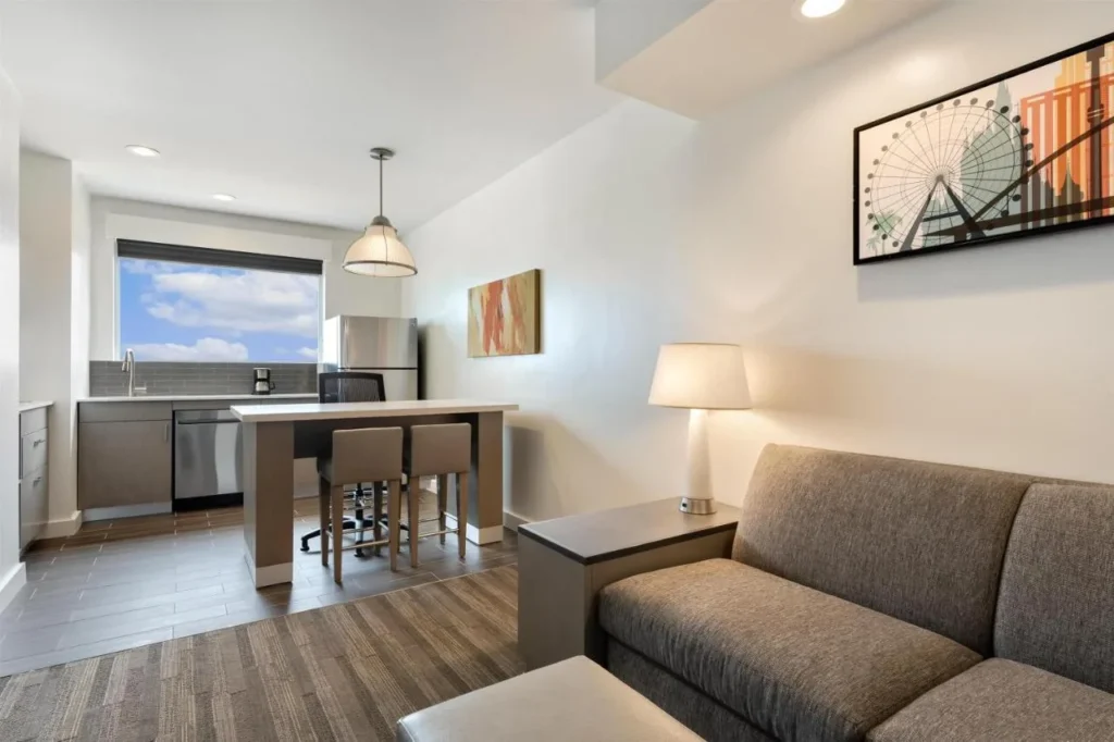 Sala de estar con sof&aacute;, barra de desayuno y cocina en Hyatt House Orlando International Drive