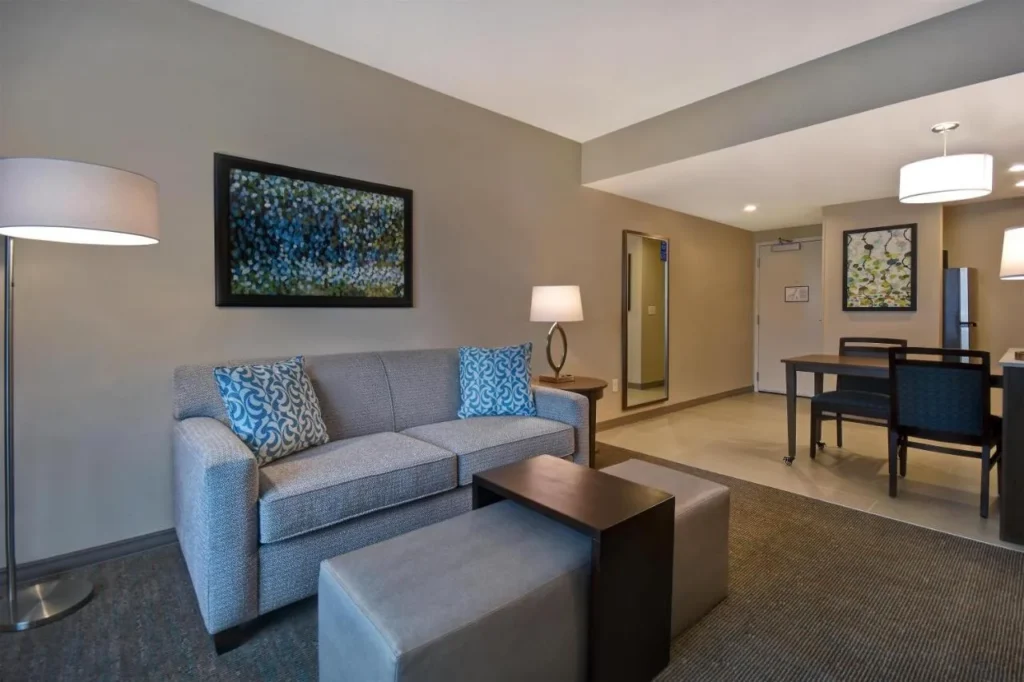 Suite living area with sofa, ottomans and dining table at Homewood Suites Flamingo Crossings