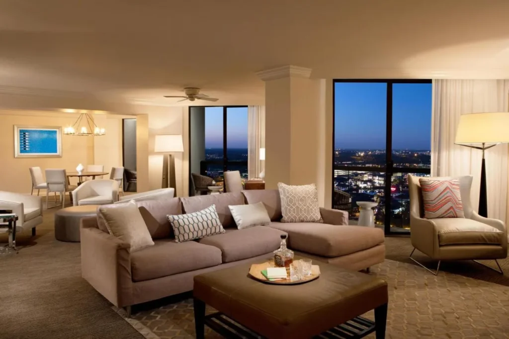 Sala de estar de la suite en el Hilton Orlando Buena Vista Palace con sof&aacute; seccional y vistas al atardecer