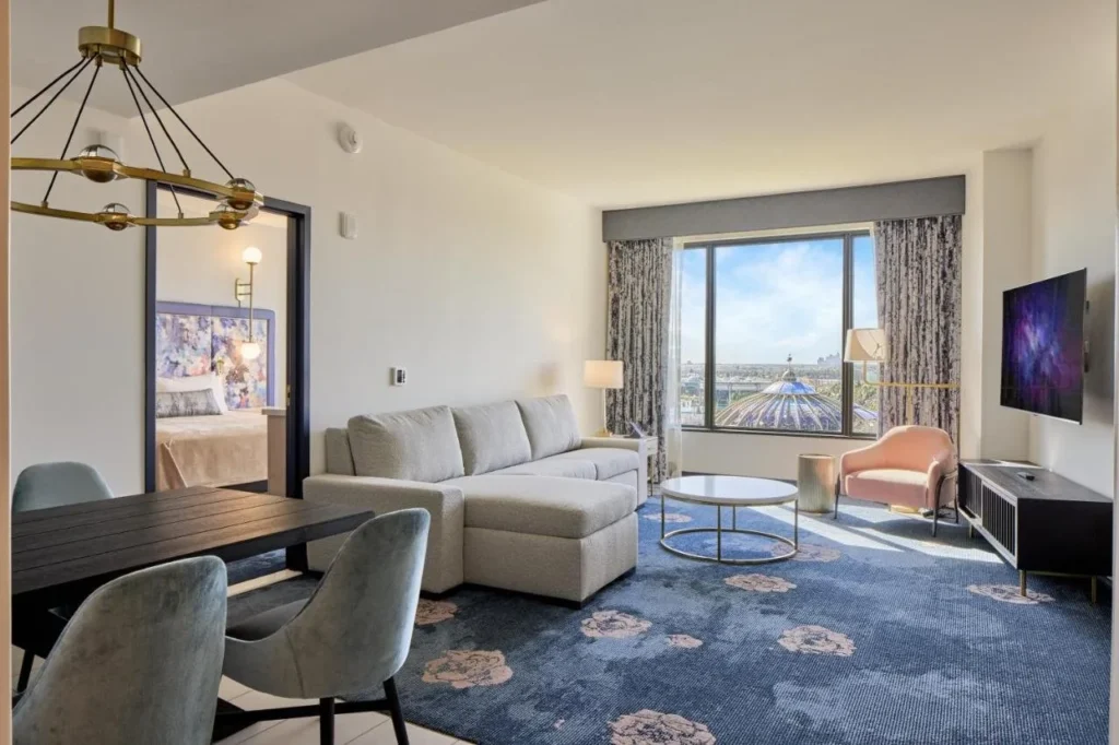 Suite living room at Universal Helios Grand Hotel with sectional sofa, dining table and large window