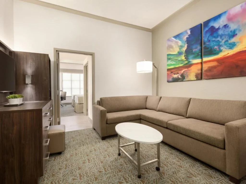 Suite living room with a sectional sofa and an open bedroom door, Buena Vista Suites