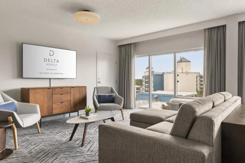 Sala de estar con sof&aacute; seccional y sillones en Delta Hotels Orlando Celebration
