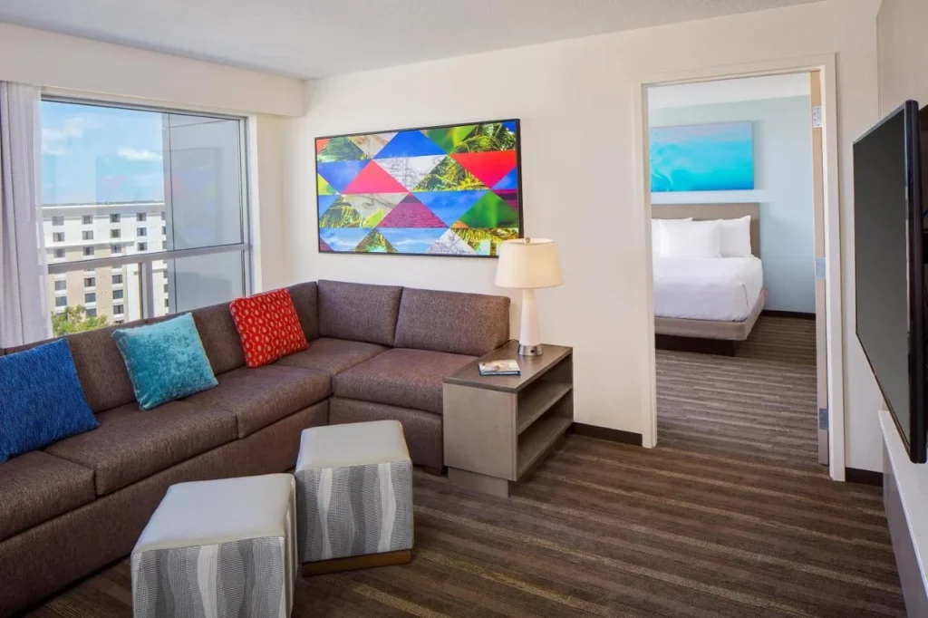 Suite living room with a sectional sofa and separate bedroom at Hyatt House across from Universal