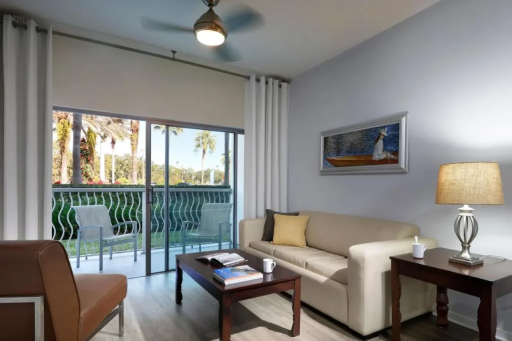 Suite living room with a sofa and sliding doors to a balcony at Meliá Orlando Celebration