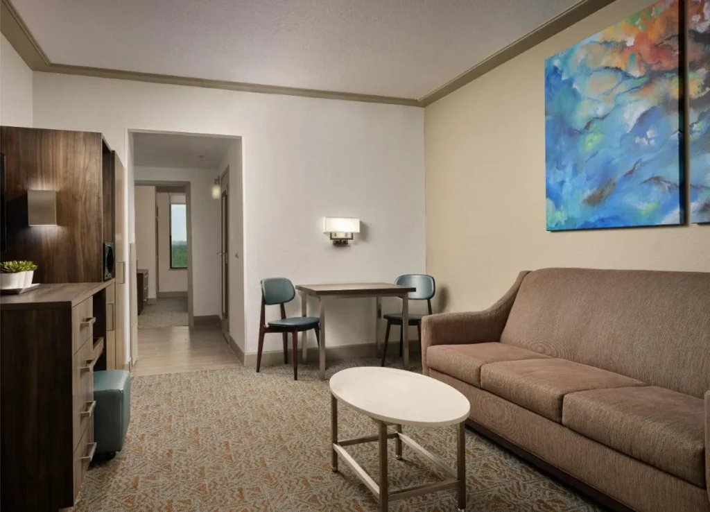 Suite living room with a sofa, coffee table and small dining table at Buena Vista Suites