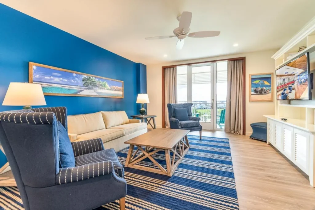 Sala de estar con sofá, sillones a rayas y puertas de balcón en Margaritaville Resort Orlando