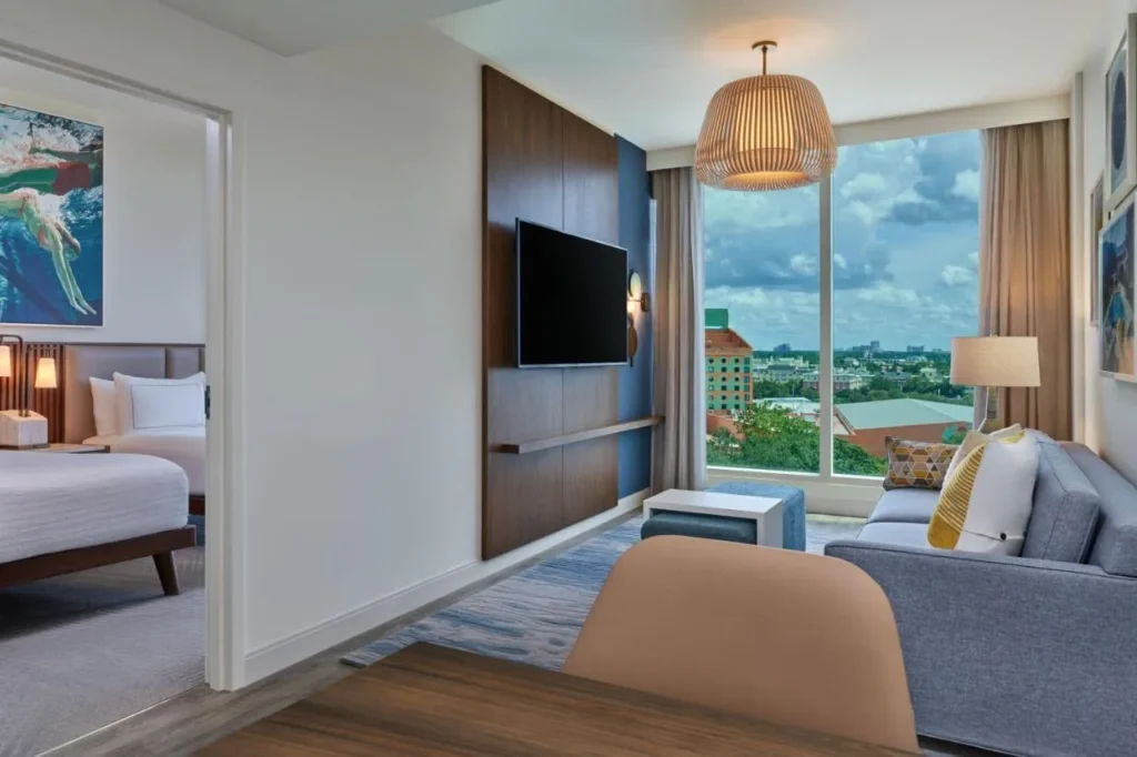 Suite living room with a sofa, TV and resort view, Walt Disney World Swan Reserve