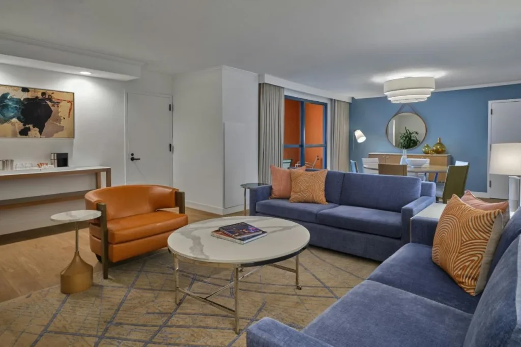 Sala de estar con sof&aacute;s azules y un sill&oacute;n de cuero en el Walt Disney World Swan