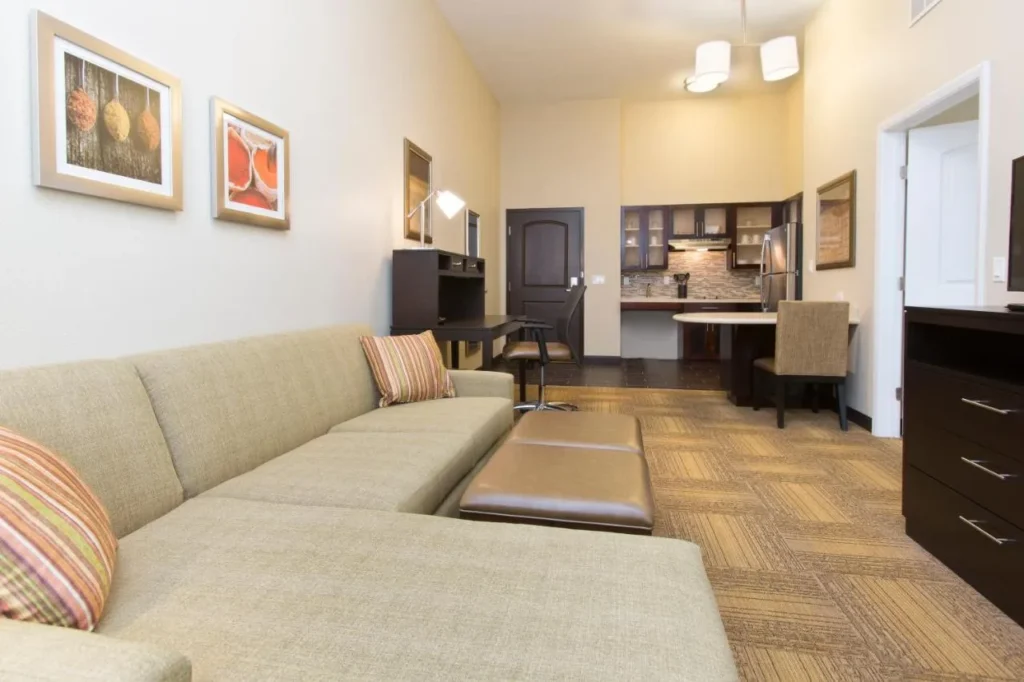 Suite con sofá seccional mirando hacia The Kitchen en Staybridge Suites Orlando at SeaWorld