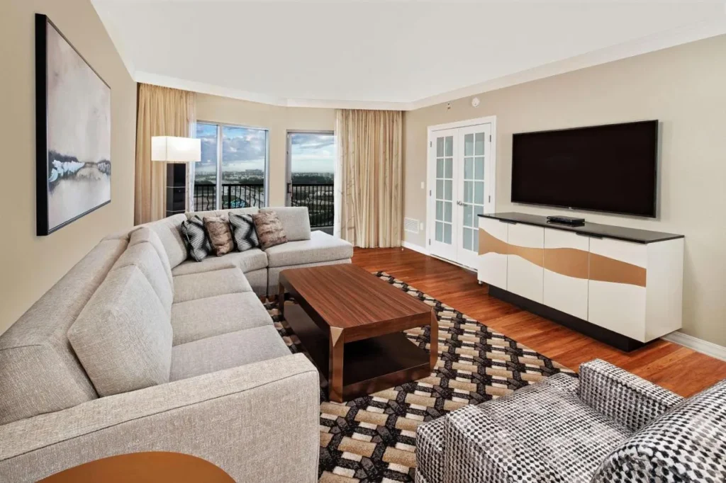 Suite con sofá seccional, TV y balcón en Hilton Grand Vacations Club Parc Soleil