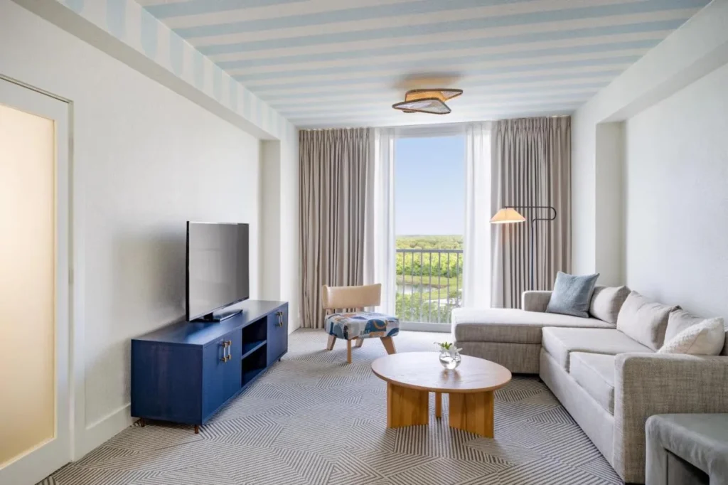Sala de estar con sofá seccional, TV y ventana alta en Renaissance Orlando Resort