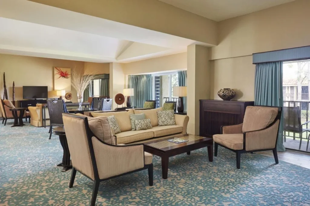 Suite living room with sofa and balcony door at the DoubleTree Orlando Theme Park Resort